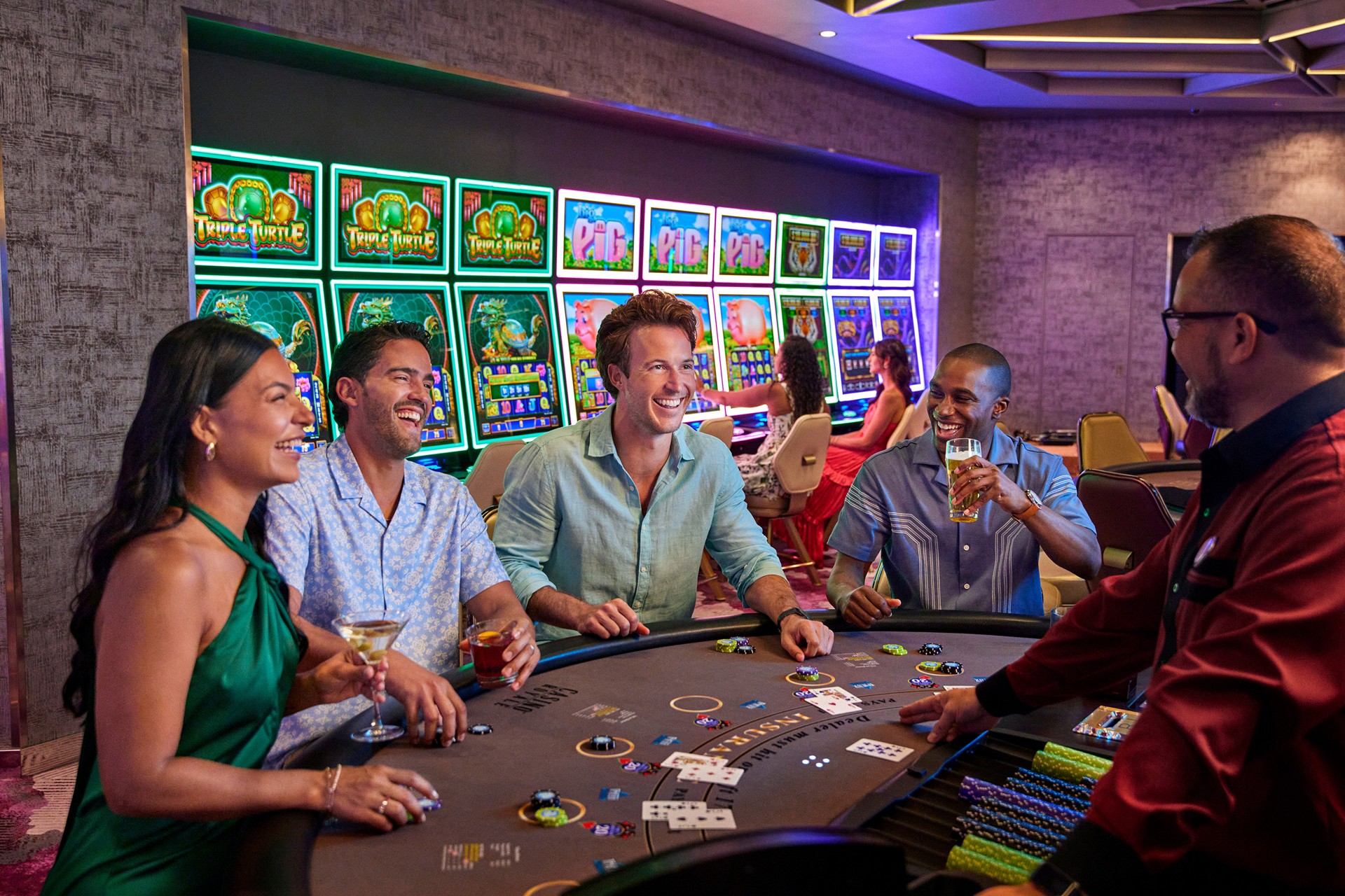 Guests and a dealer at a Casino Royale blackjack table, with slot machines behind them