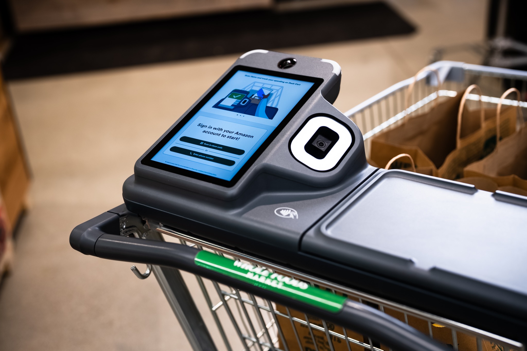 Close-up of a Dash Cart touchscreen, scanner, handle and shopping bags